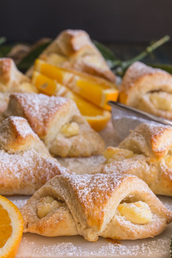 croissants on a white board dusted with powdered sugar