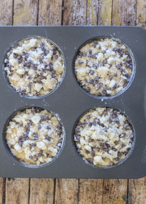 The muffins in a muffin tin before baking.
