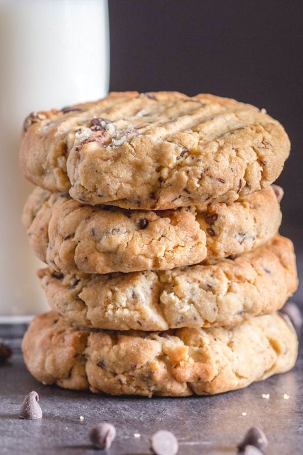 4 peanut butter chocolate chip cookies stacked with a glass of milk