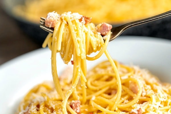 classic carbonara in a plate on a fork