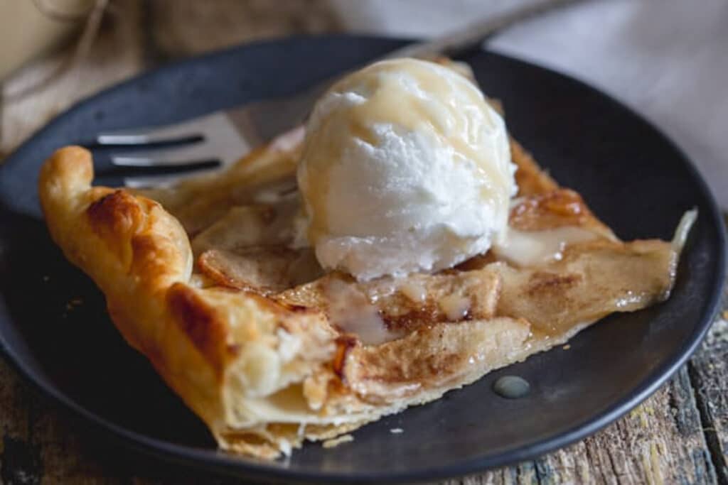 A slice of tart on a scoop of ice cream.