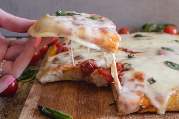 no knead pizza dough - pizza Margherita with a slice cut