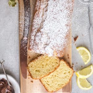 Plumcake with 2 slices cut on a wooden board.