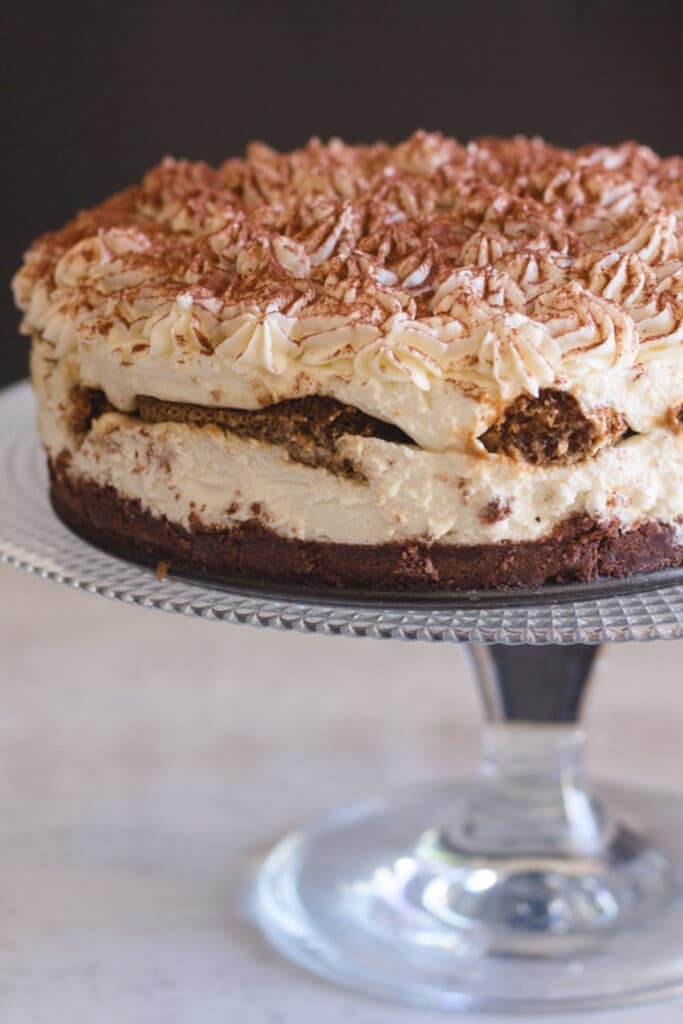 Cheesecake on a glass cake dish.