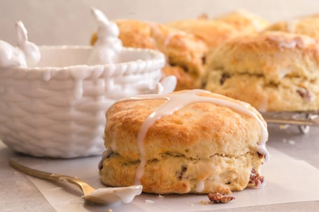 A scone on a piece of parchment paper and on a wire rack.