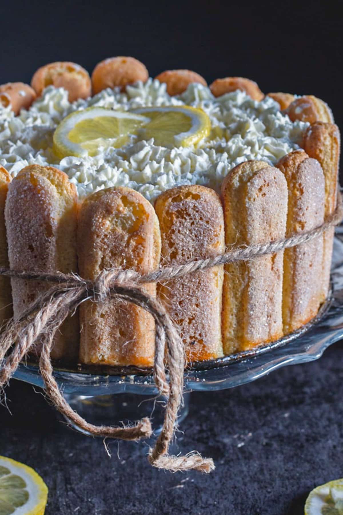 Lemon charlotte on a black cake stand.