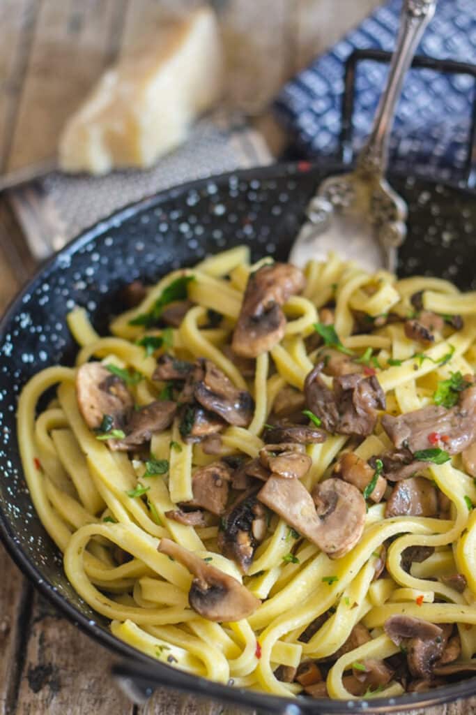 Mushroom pasta in the pan with a fork.