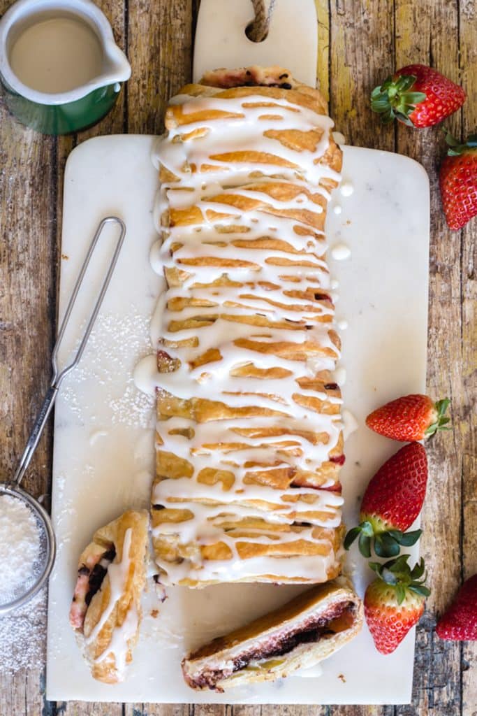 Strawberry strudel with 2 slices cut on a white board.