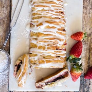 Strawberry strudel with 2 slices cut on a white board.