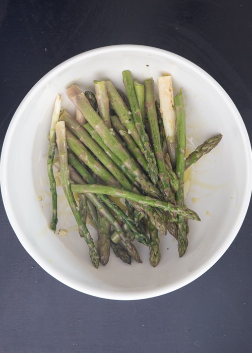 The asparagus tossed with the olive oil mixture.