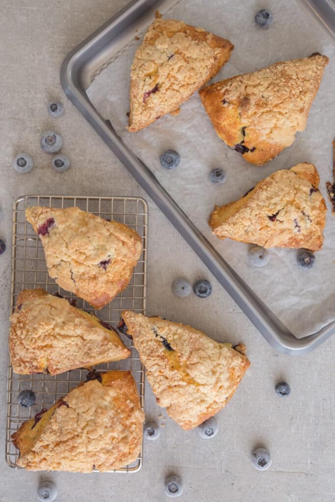 Scones on a wire rack and on a grey board.