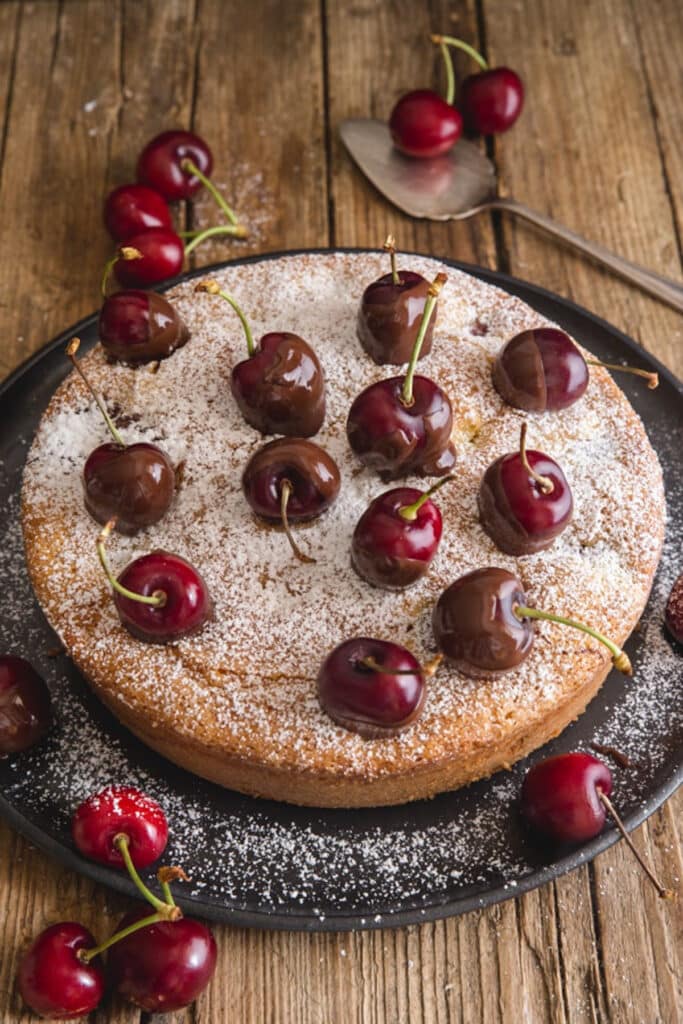 Cherry cake on a black wire rack.