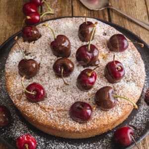 Cherry cake on a black wire rack.