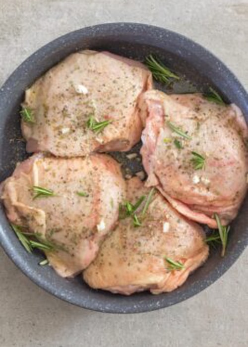 Raw chicken in a pan.