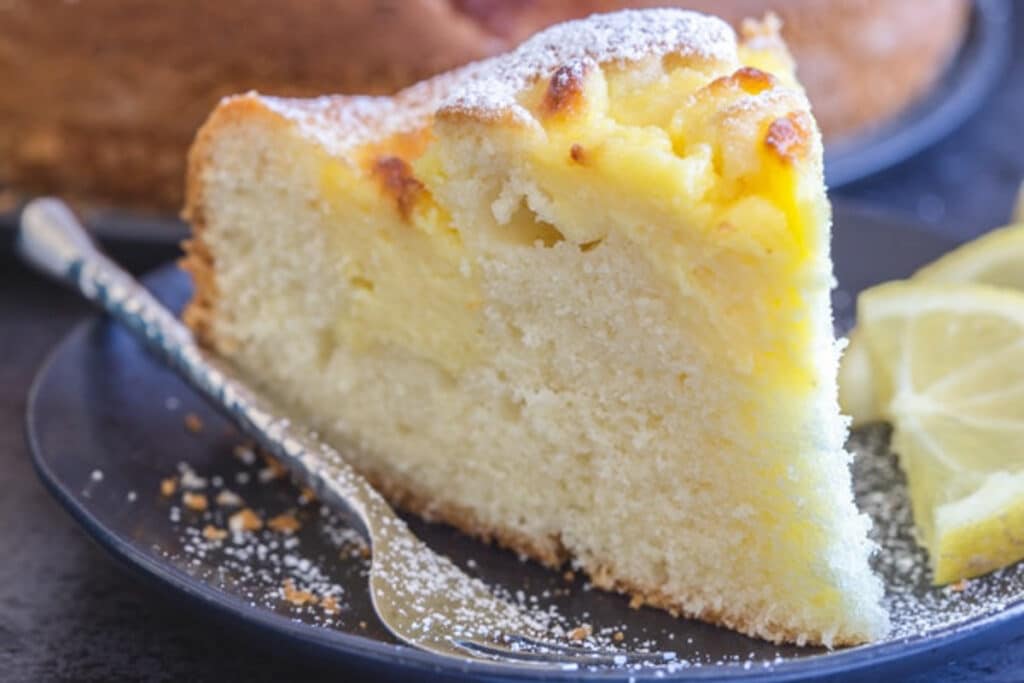 A slice of cake on a black plate.