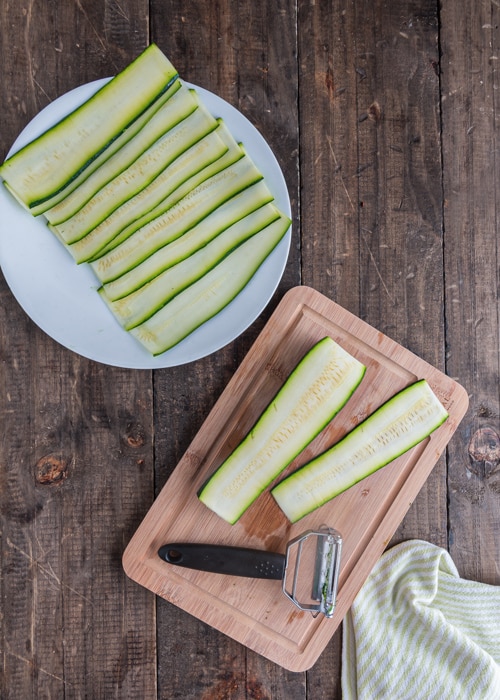 The zucchini sliced on a plate and on a wooden board.