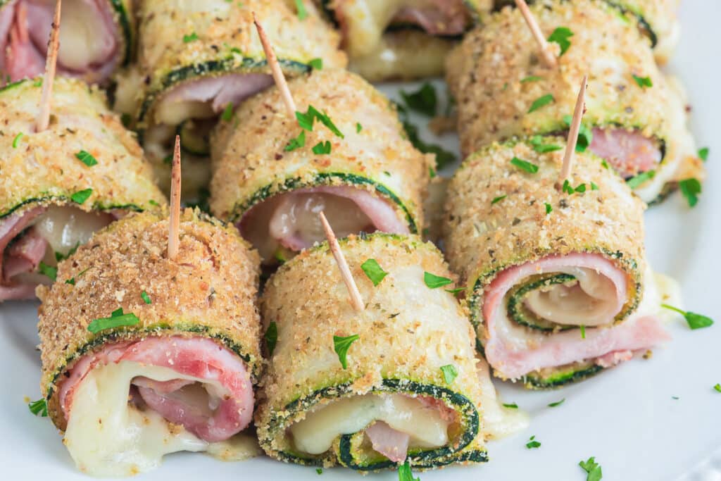 Zucchini rollups on a white plate.