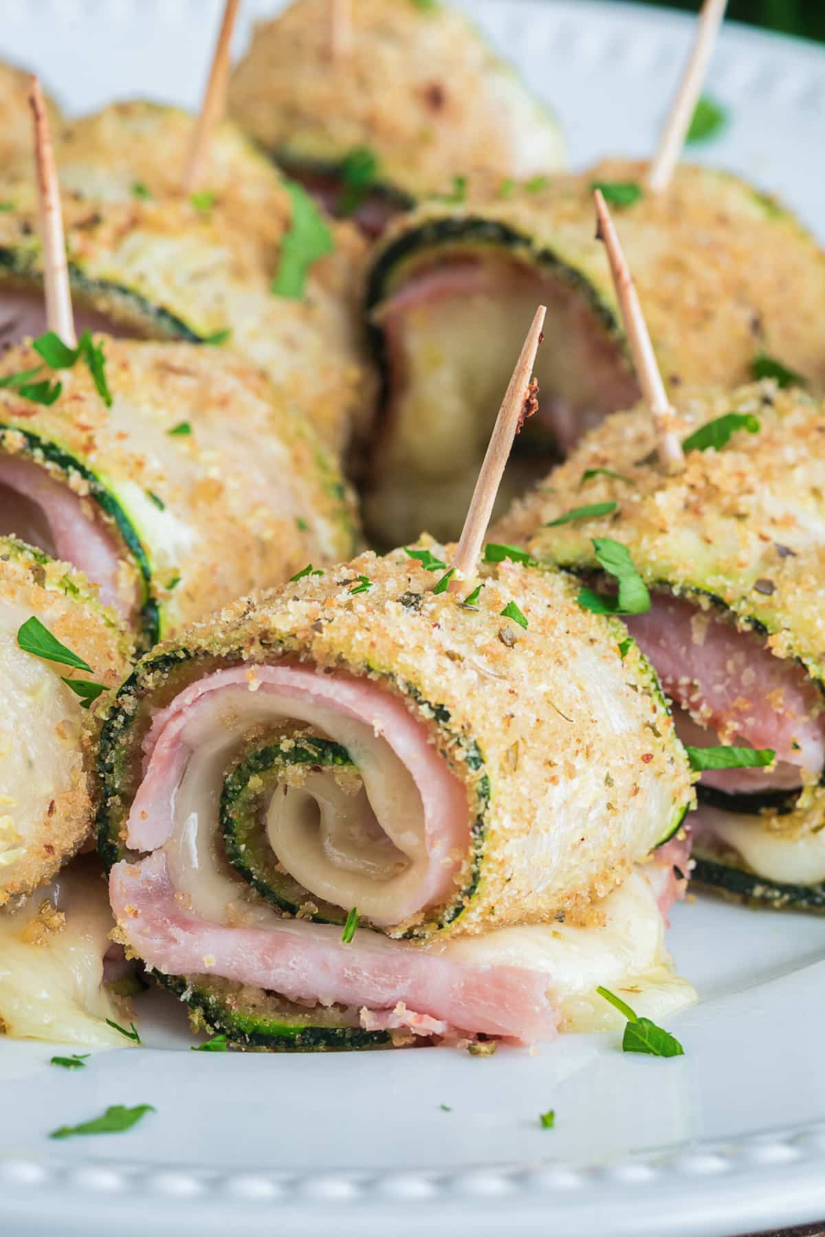 Zucchini rollups on a white plate.