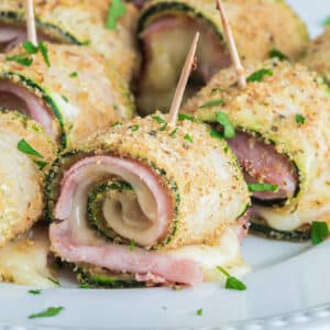 Zucchini rollups on a white plate.