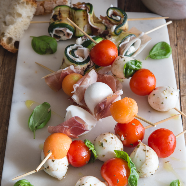 antipasto skewers on a white board