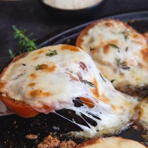 lifting a baked tomato with cheese pull