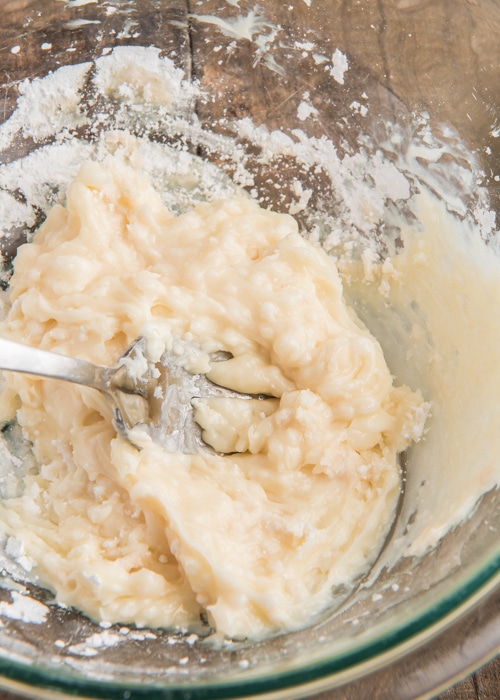 Making the cream cheese frosting in a glass bowl.