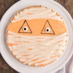 Mummy halloween cookie cake on a white plate.