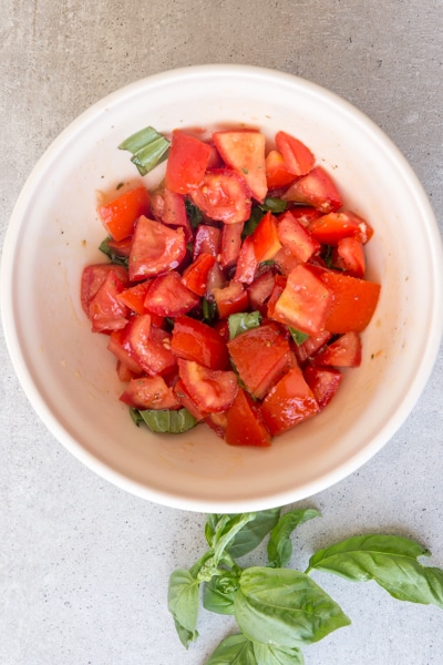 how to make pasta alla checca ingredients tossed in a white bowl