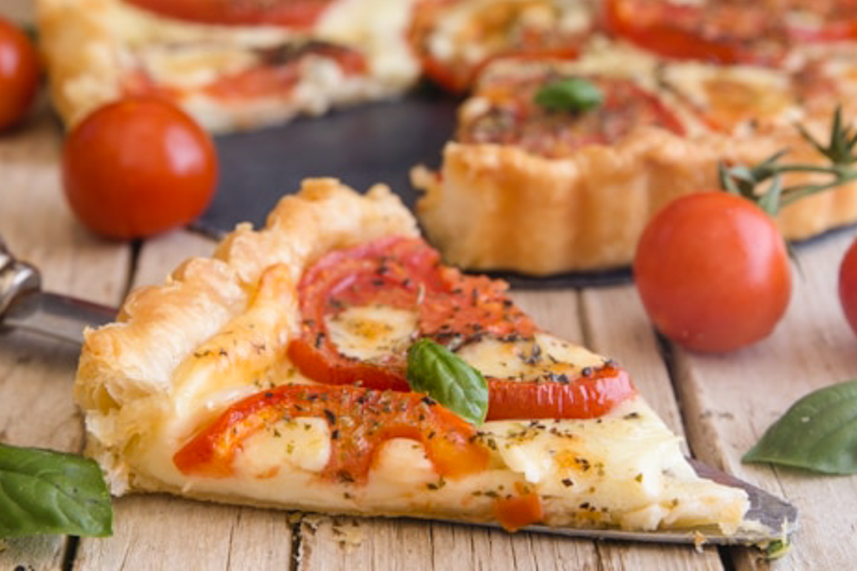 an up close photo of a slice of tomato pie.