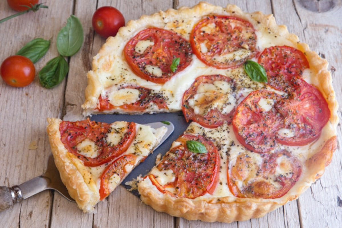 Tomato pie with a slice cut on a cake server.