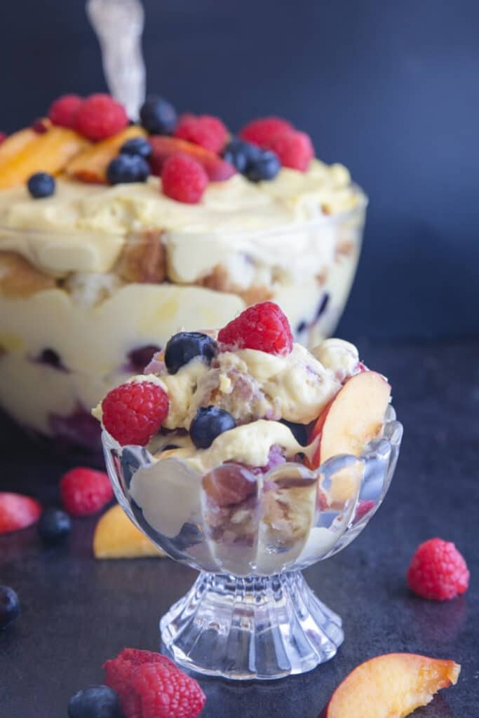 Berry trifle in a bowl and some in a serving bowl.