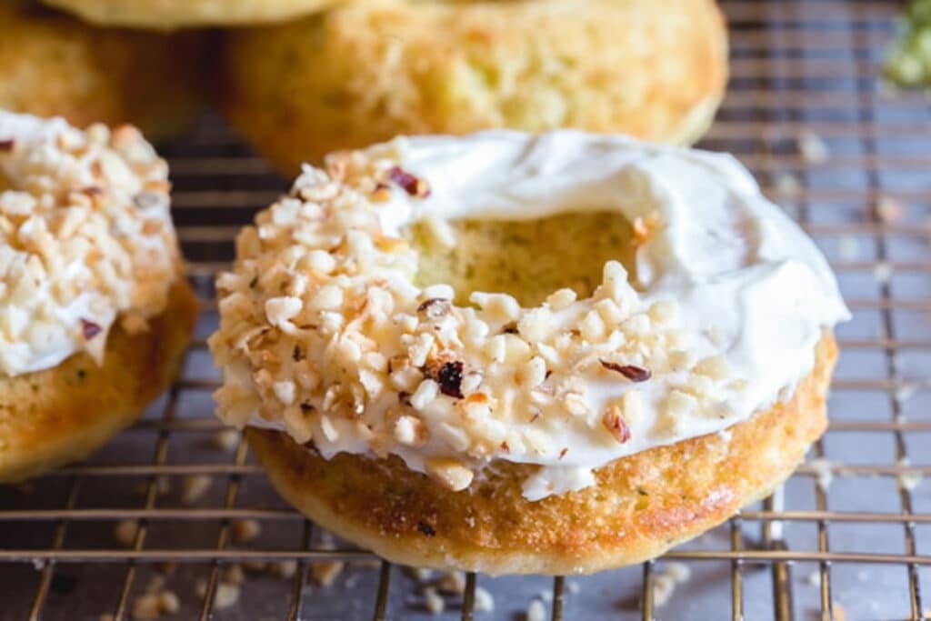 Donut frosted and sprinkled with nuts on a wire rack.