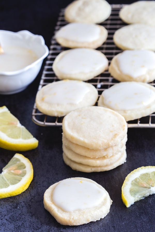 lemon cookies stacked and on a wire rack