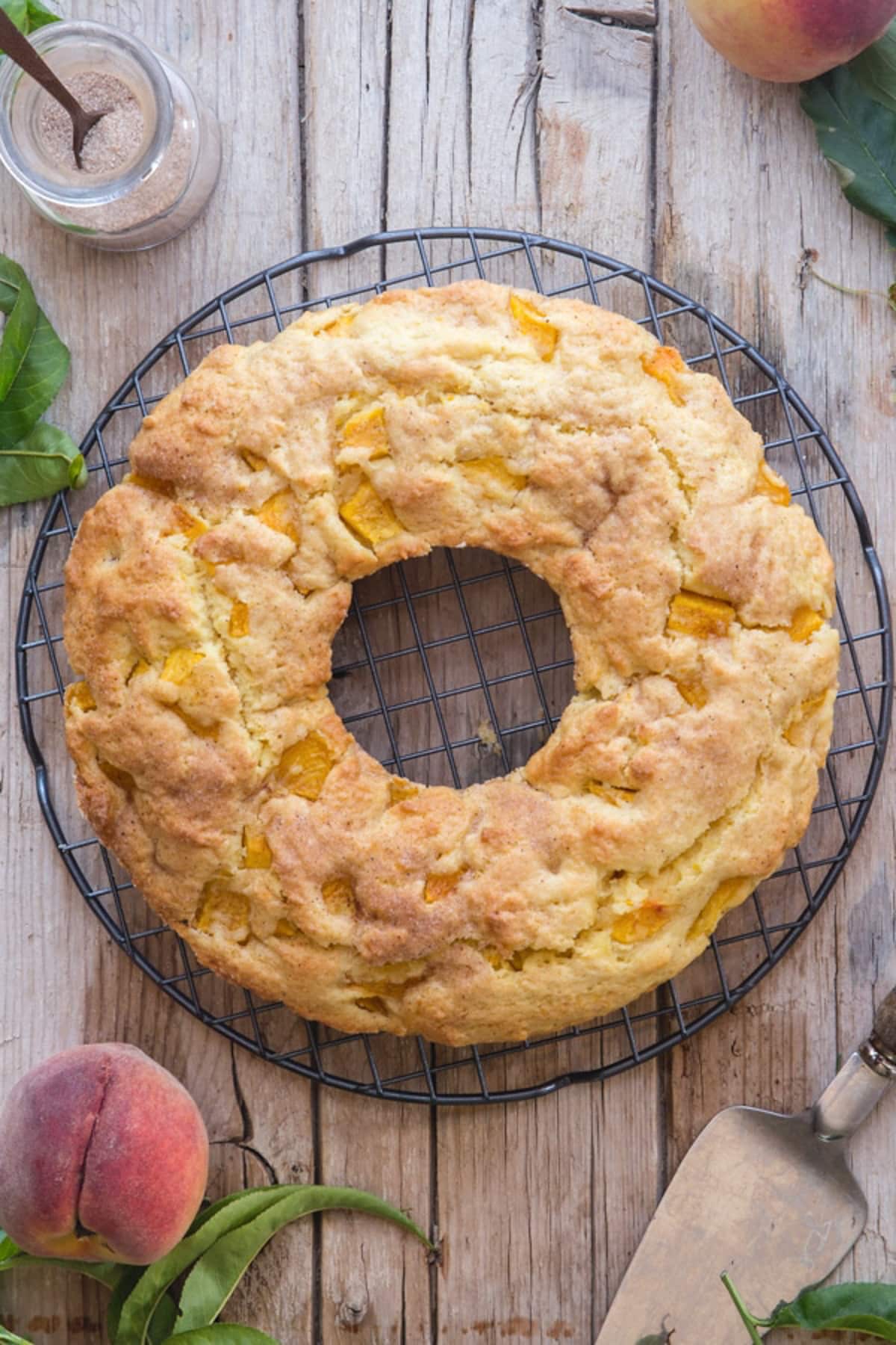 Peach cake on a black wire rack.