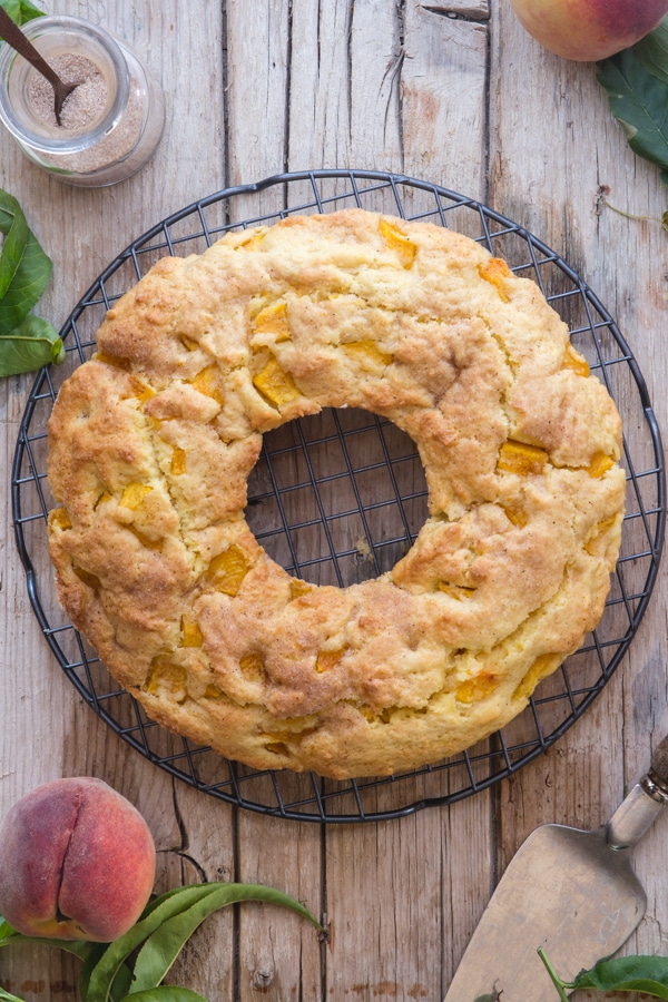 peach cake on a black wire rack