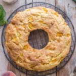 Peach cake on a black wire rack.