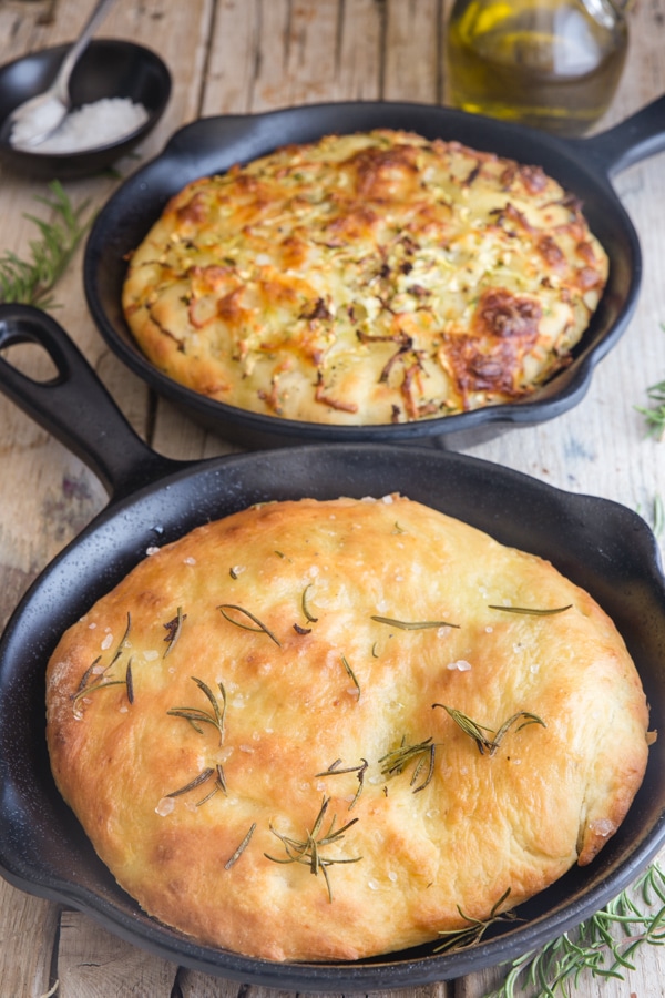 potato focaccia in 2 black pans, rosemary & zucchini and cheese