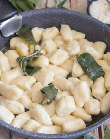 Gnocchi with ricotta in a black pan with a spoon.