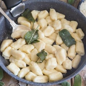 Gnocchi with ricotta in a black pan with a spoon.