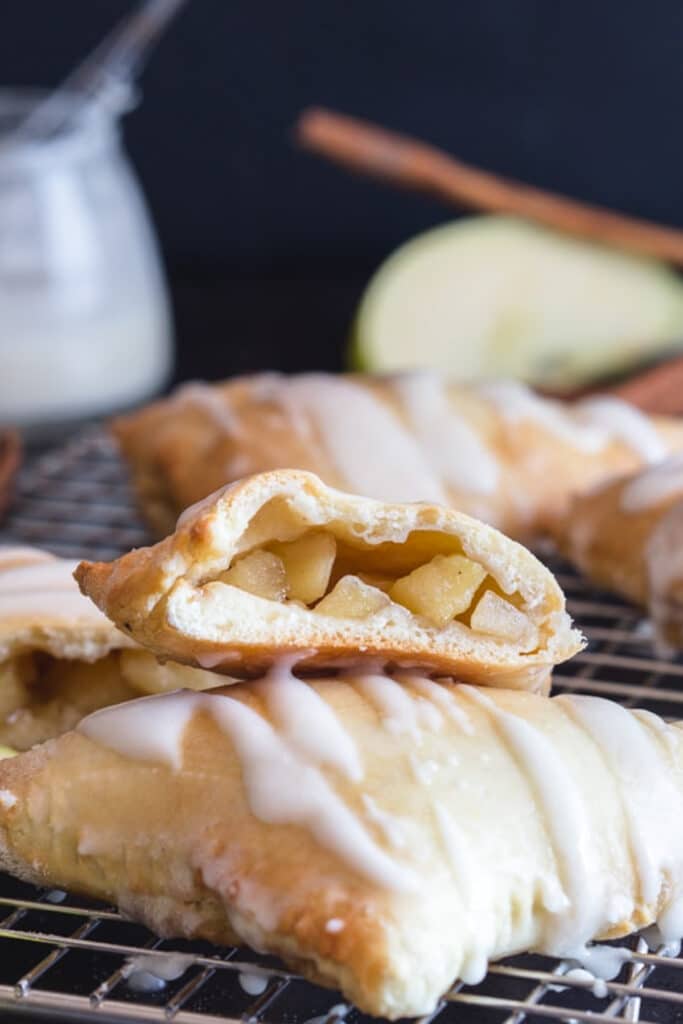 Turnovers on a wire rack with one cut in half.