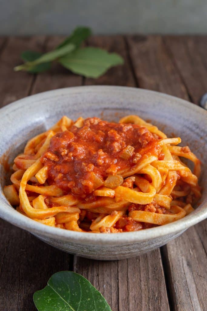 Bolognese sauce and pasta in a grey bowl.