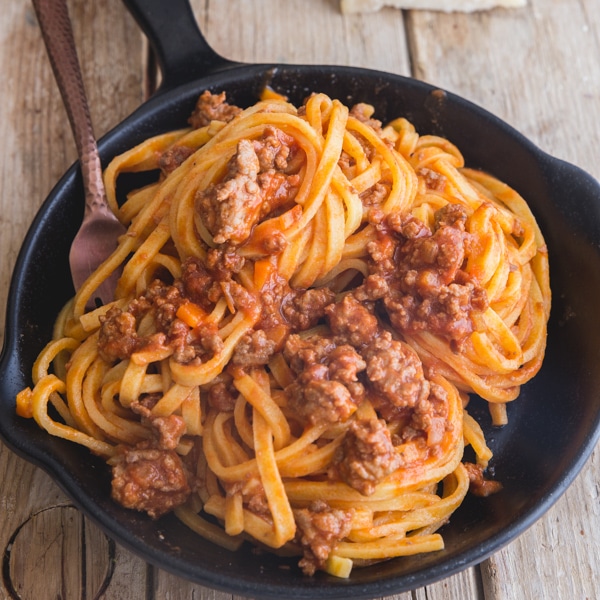 bolognese sauce with pasta in a black pan