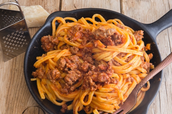 bolognese sauce with pasta in a black pan