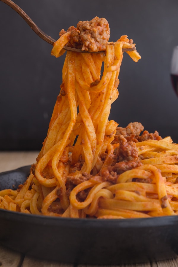 a fork of pasta and bolognese sauce