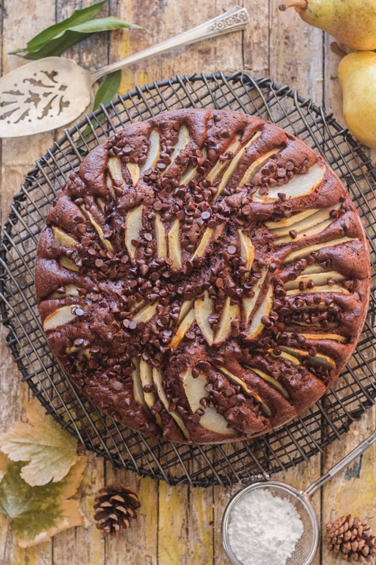 Chocolate pear cake on a black wire rack.