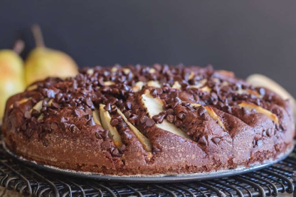 Chocolate pear cake on a black wire rack.