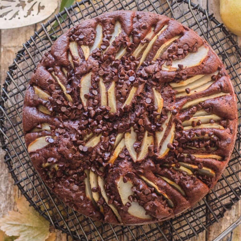 Chocolate pear cake on a black wire rack.