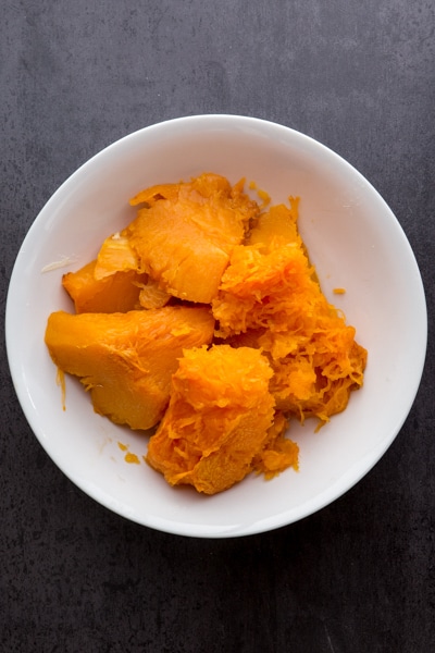 pulp removed from the skin of the pumpkin chunks and placed in a white bowl