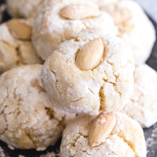 almond cookies on a black plate stacked