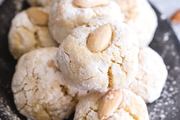 up close almond cookies on a black plate